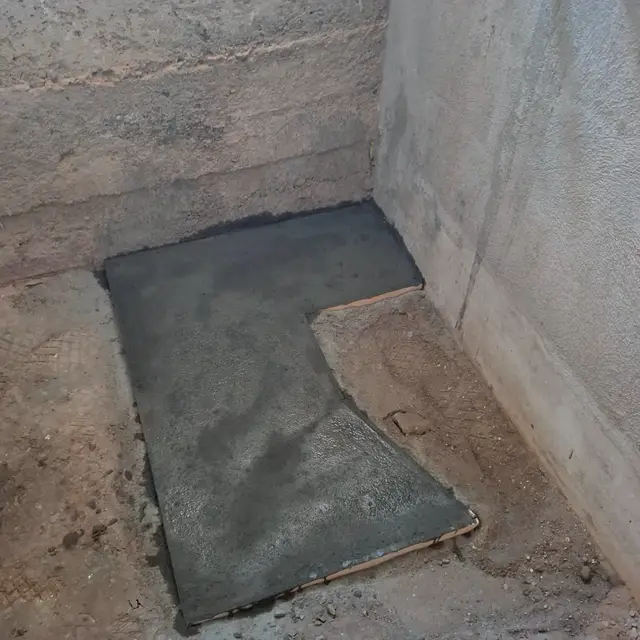 Dalle en béton fraîchement coulée à l'emplacement de la future douche