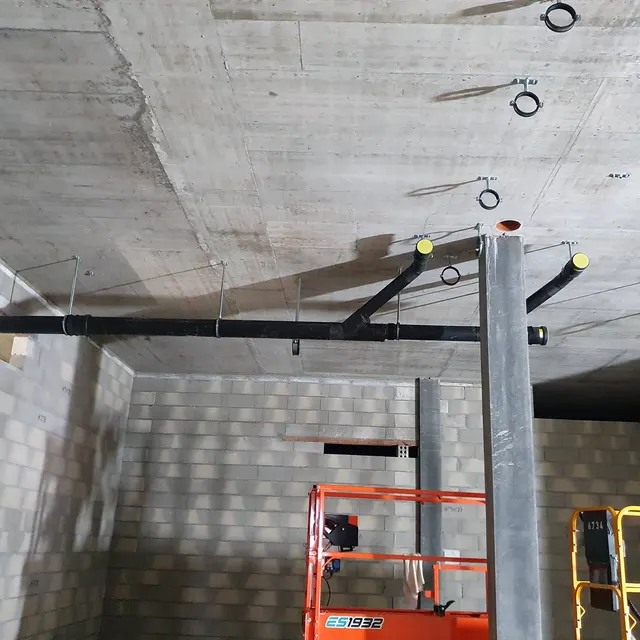 Conduites d'évacuation fixées au plafond en béton d'un sous-sol en construction